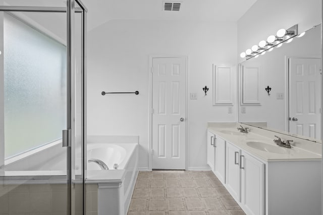 bathroom featuring vanity, vaulted ceiling, and independent shower and bath