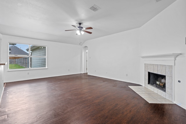 unfurnished living room featuring a tiled fireplace, ceiling fan, hardwood / wood-style floors, and a textured ceiling