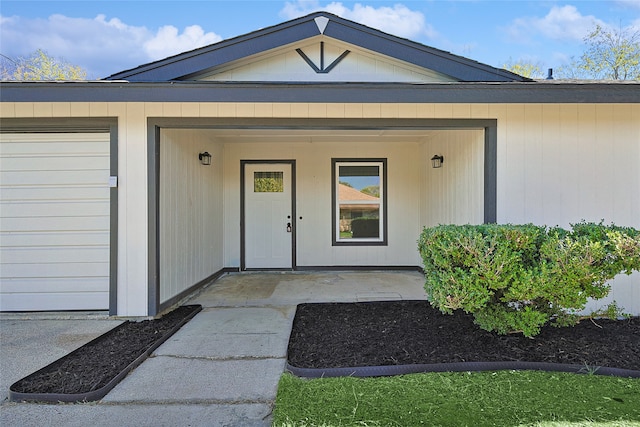 view of exterior entry with covered porch and a garage