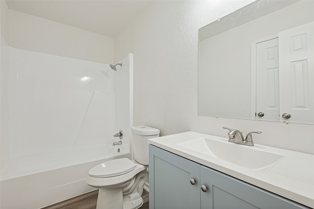 full bathroom featuring hardwood / wood-style floors, vanity, toilet, and shower / washtub combination