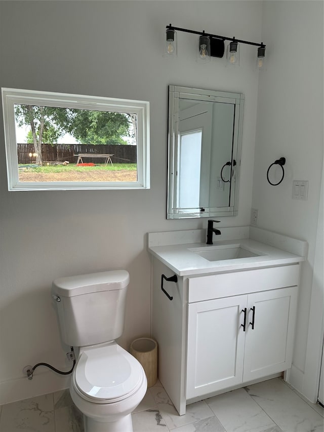 bathroom featuring vanity, toilet, and a wealth of natural light