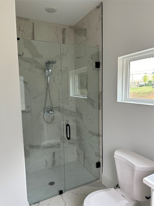 bathroom featuring toilet and a shower with shower door