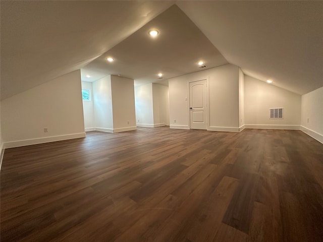 additional living space with dark hardwood / wood-style flooring and lofted ceiling