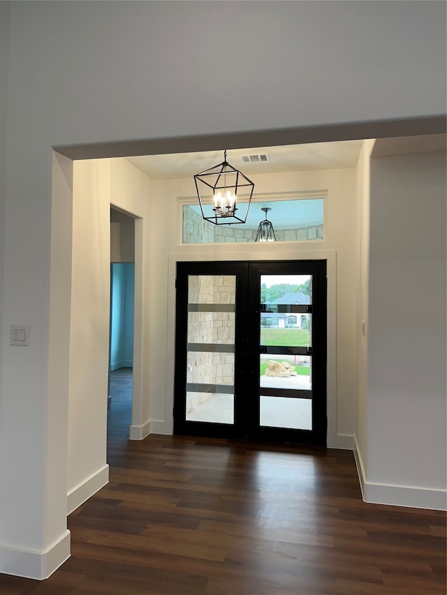 entryway with a notable chandelier, dark wood-type flooring, and french doors