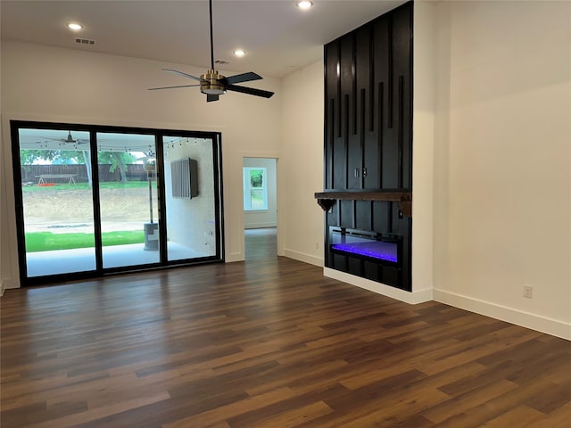 unfurnished living room featuring dark hardwood / wood-style floors, high vaulted ceiling, ceiling fan, and a healthy amount of sunlight