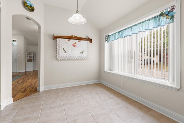 spare room featuring light hardwood / wood-style flooring and vaulted ceiling