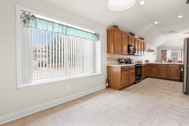 kitchen with sink, tasteful backsplash, vaulted ceiling, light tile patterned floors, and black appliances