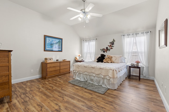 bedroom featuring hardwood / wood-style floors, vaulted ceiling, multiple windows, and ceiling fan