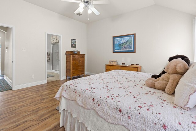 bedroom with hardwood / wood-style floors, ensuite bathroom, vaulted ceiling, and ceiling fan