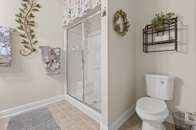 bathroom with tile patterned floors, a shower with door, and toilet