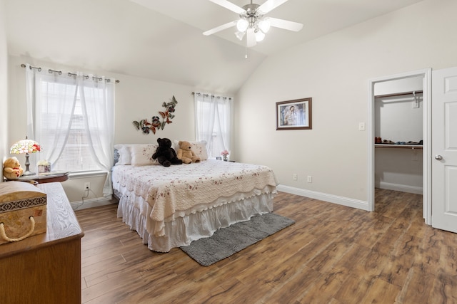 bedroom featuring a spacious closet, ceiling fan, vaulted ceiling, a closet, and hardwood / wood-style flooring