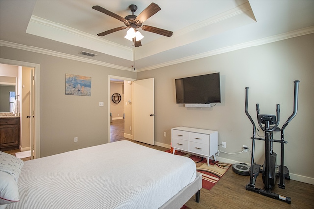 bedroom with hardwood / wood-style flooring, a raised ceiling, ceiling fan, and ornamental molding