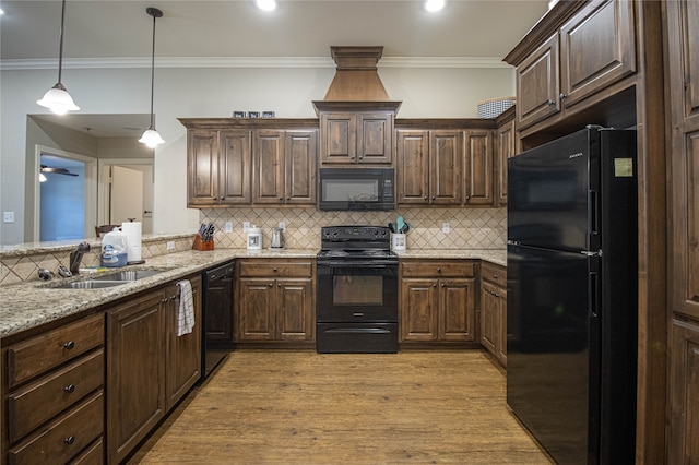 kitchen featuring black appliances, dark brown cabinetry, sink, and light hardwood / wood-style flooring