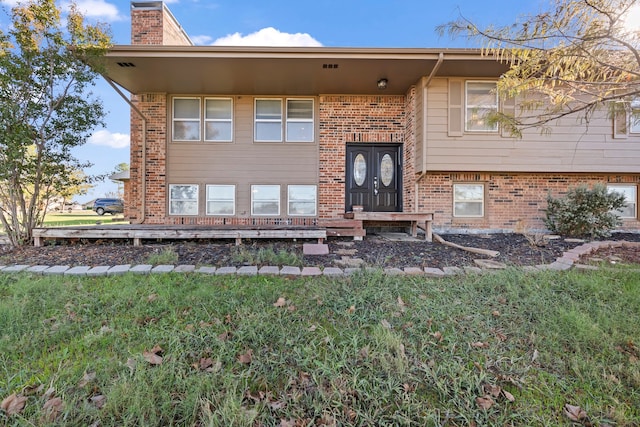 property entrance featuring a lawn