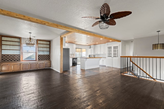 unfurnished living room featuring beam ceiling, dark hardwood / wood-style floors, and a wealth of natural light