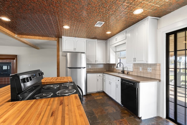 kitchen with appliances with stainless steel finishes, tasteful backsplash, white cabinetry, and sink