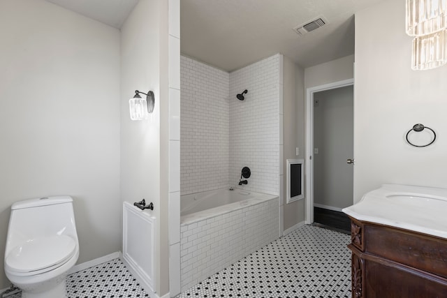 full bathroom with vanity, tile patterned flooring, tiled shower / bath, and toilet