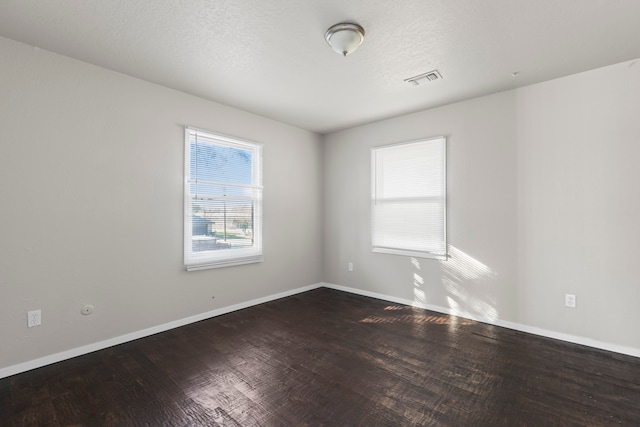 empty room featuring wood-type flooring and a textured ceiling