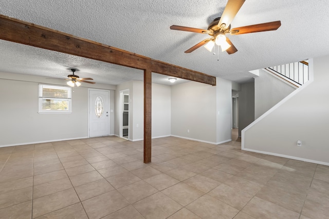 unfurnished living room with ceiling fan, light tile patterned floors, and a textured ceiling