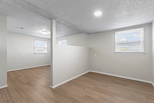 spare room featuring hardwood / wood-style floors and a textured ceiling