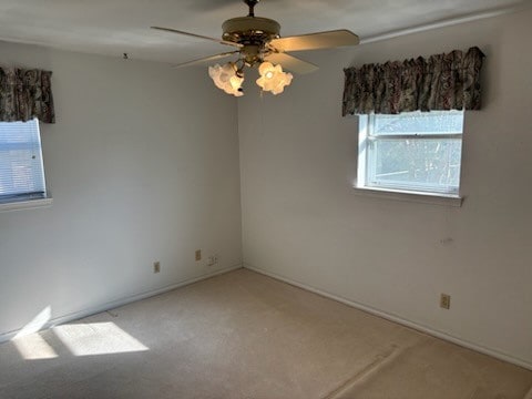 spare room with carpet flooring, ceiling fan, and plenty of natural light