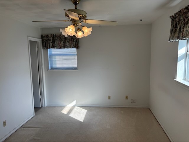 spare room featuring ceiling fan and light colored carpet