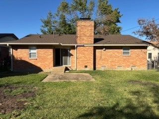 rear view of property featuring a lawn and a patio area