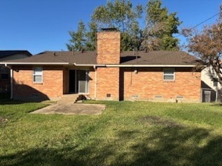 back of house featuring a lawn and a patio area