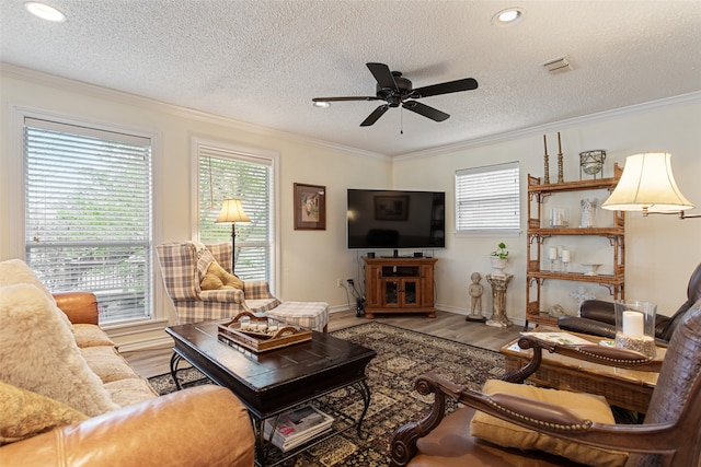 living room featuring hardwood / wood-style floors, a textured ceiling, ceiling fan, and ornamental molding