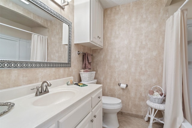 bathroom featuring tile patterned floors, vanity, toilet, and a textured ceiling