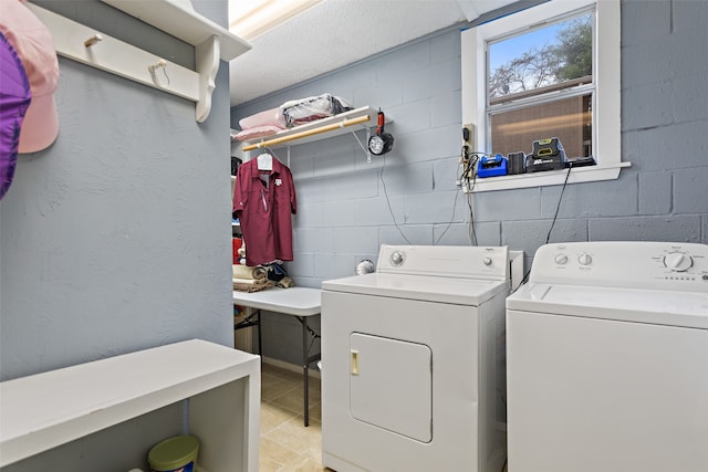 clothes washing area featuring independent washer and dryer, a textured ceiling, and light tile patterned floors