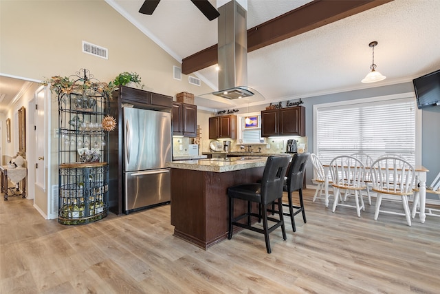 kitchen with decorative light fixtures, stainless steel fridge, light wood-type flooring, and island exhaust hood