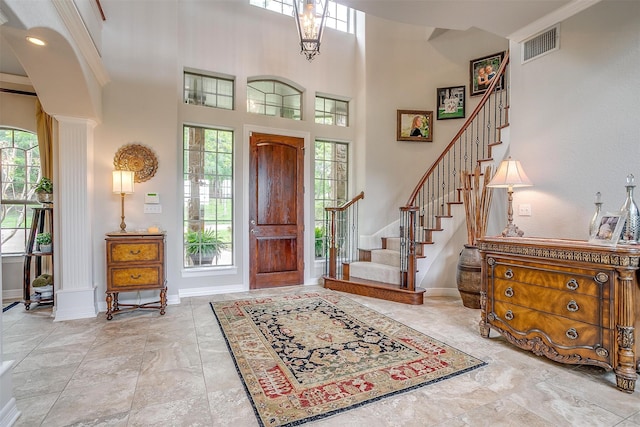 entryway with a high ceiling and crown molding