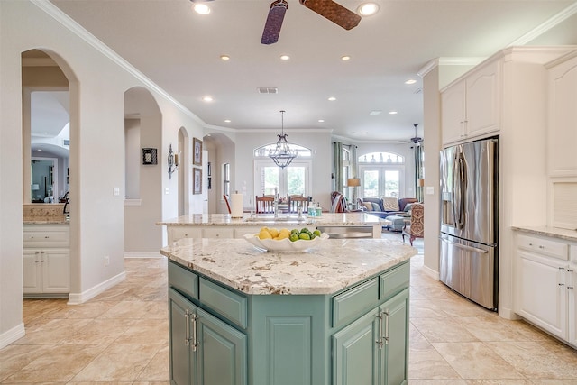 kitchen featuring crown molding, green cabinetry, a kitchen island, white cabinetry, and stainless steel appliances