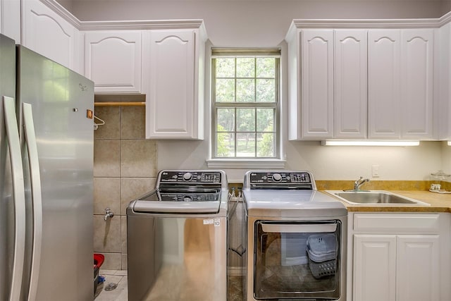 laundry area with washer and clothes dryer, cabinets, and sink