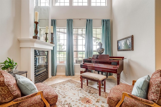 living area featuring plenty of natural light, light tile patterned floors, and a tiled fireplace