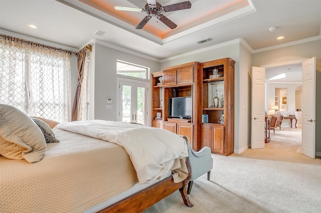 bedroom with light carpet, french doors, ceiling fan, ornamental molding, and a tray ceiling