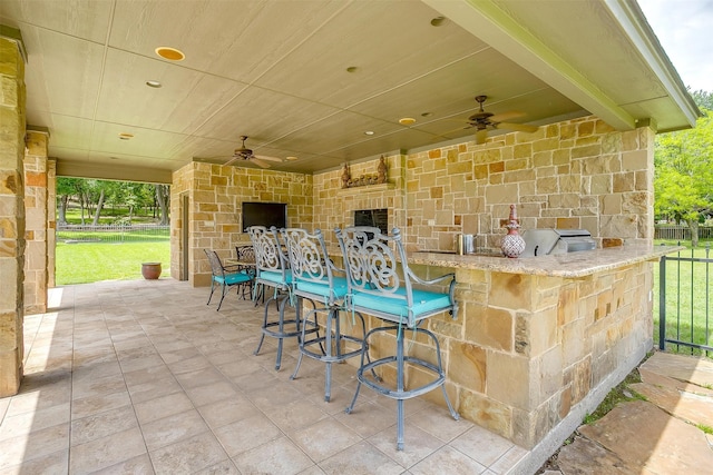 view of patio / terrace with an outdoor bar, ceiling fan, and a grill