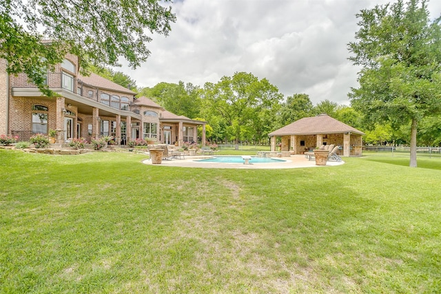 view of yard with an outdoor kitchen, a balcony, and a patio