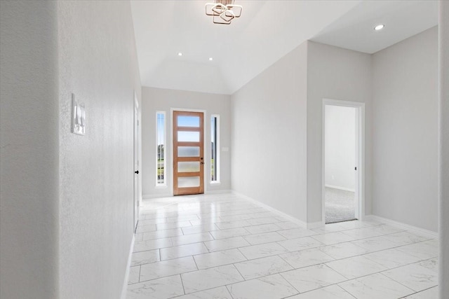 foyer with lofted ceiling and an inviting chandelier