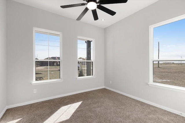 spare room with carpet flooring, ceiling fan, and a healthy amount of sunlight