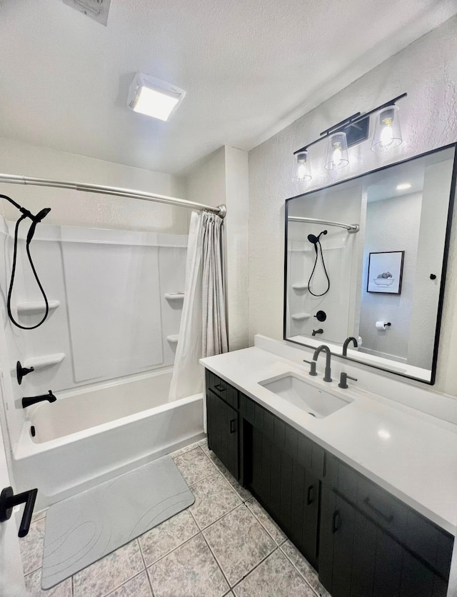 bathroom with vanity, a textured wall, tile patterned floors, shower / bath combination with curtain, and a textured ceiling