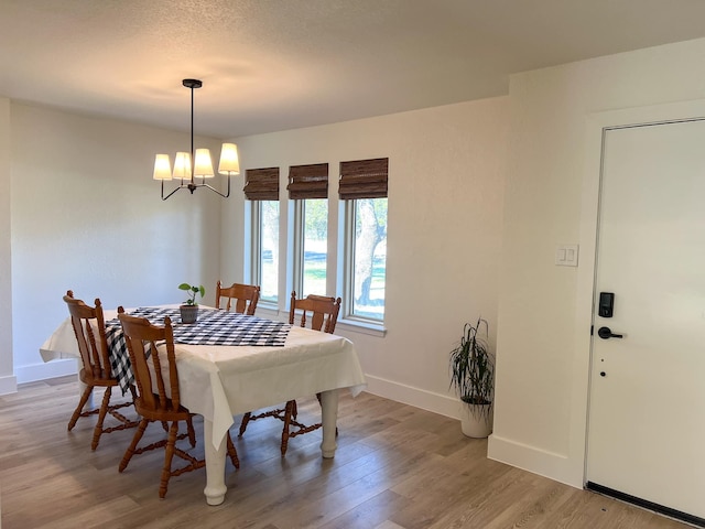 dining space with an inviting chandelier and light hardwood / wood-style flooring