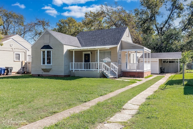 bungalow-style house featuring covered porch, an outbuilding, a garage, and a front lawn