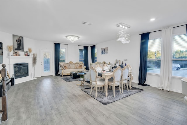 dining area with light wood-type flooring and an inviting chandelier