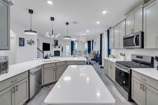 kitchen featuring a center island, stainless steel appliances, gray cabinets, and sink