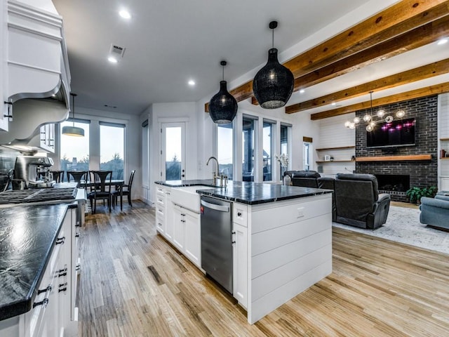 kitchen with sink, white cabinets, hanging light fixtures, stainless steel dishwasher, and a center island with sink