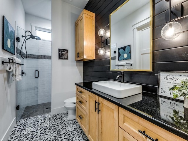 bathroom with vanity, a shower with shower door, tile patterned floors, and toilet