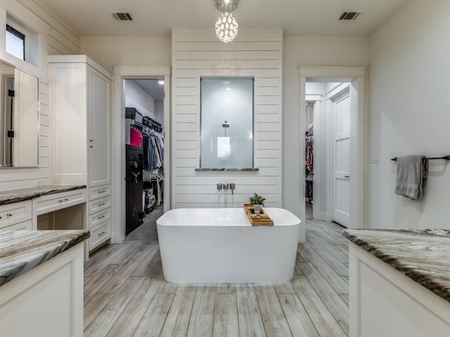 bathroom featuring vanity, hardwood / wood-style flooring, and a tub