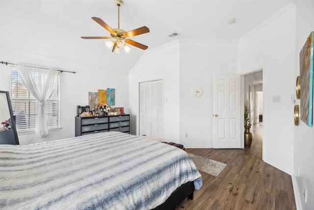 bedroom featuring ornamental molding, vaulted ceiling, ceiling fan, dark wood-type flooring, and a closet